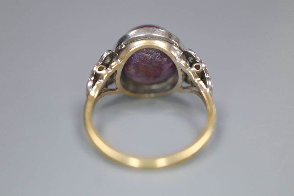 An 18ct and plat, cabochon purple star sapphire set ring, with diamond set shoulders, size N, gross 7.3 grams.